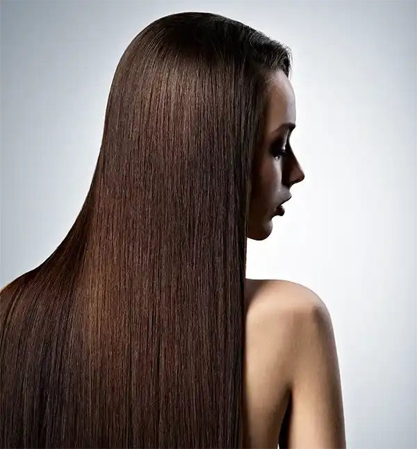 Jeune femme brune de dos, de long cheveux lisse couvre son dos.